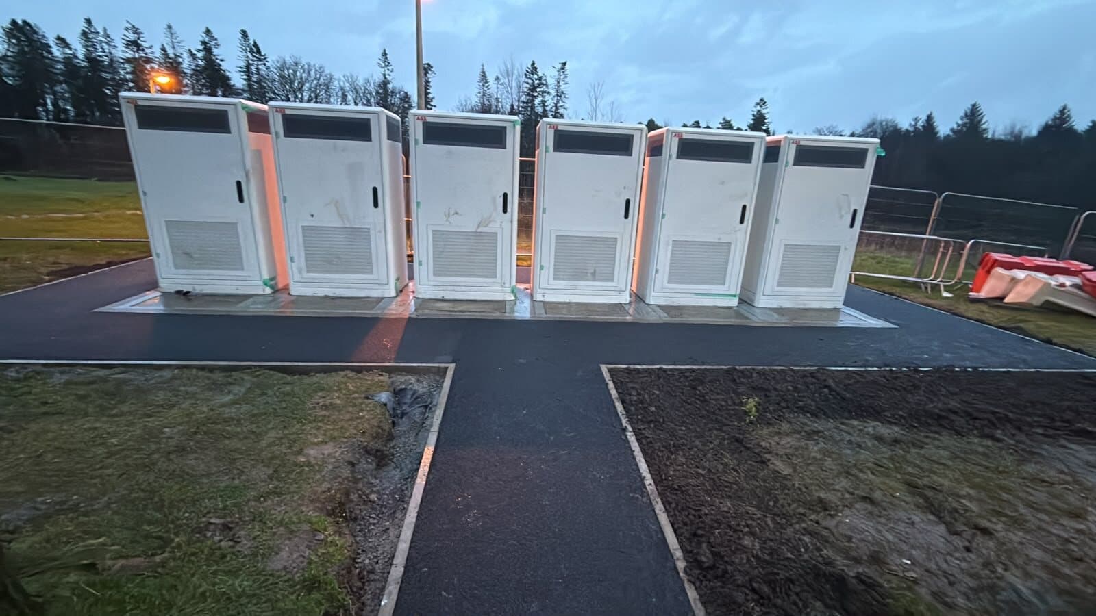 Bank of rapid car chargers installed on new tarmac at a charging hub
