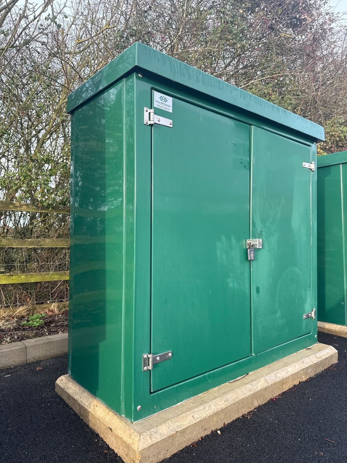Finished substation kiosk standing on its concrete plinth with the ground reinstated around it